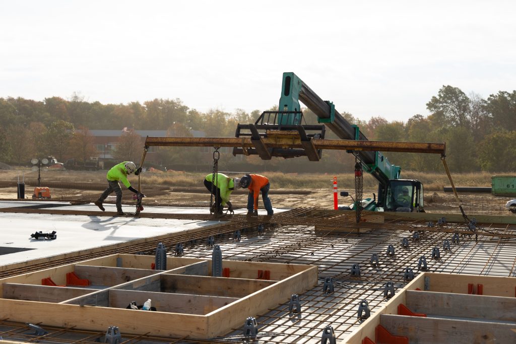 3 workers preparing tilt panel casts for a concrete pour.