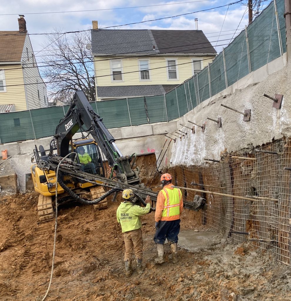Hollow bar anchors being drilled into a retaining wall.